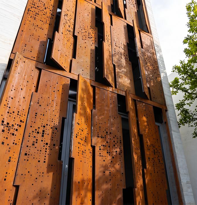 Panneaux architecturaux perforés en acier Corten sur bâtiment contemporain