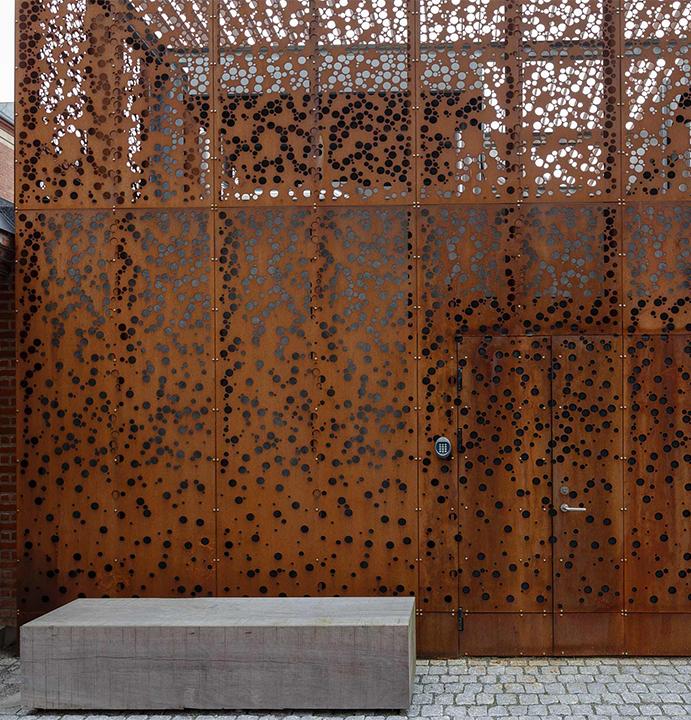 Façade en acier Corten perforé avec porte intégrée