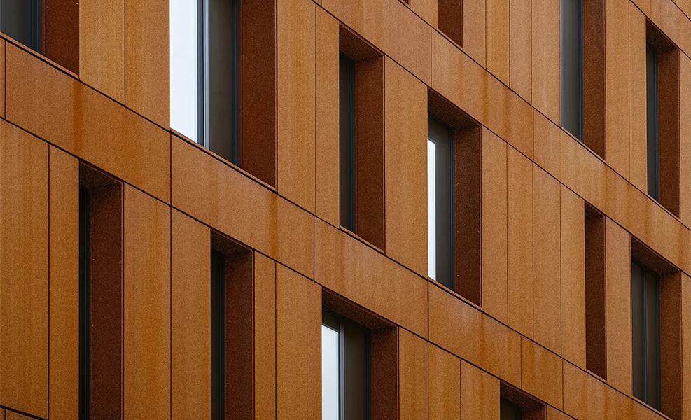Façade de bâtiment contemporain en acier Corten avec trame répétitive