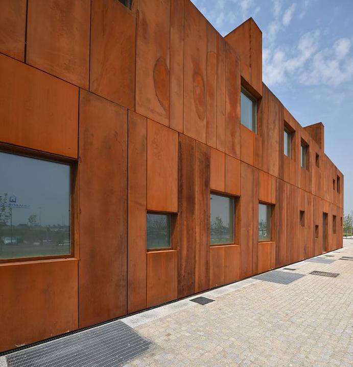 Façade de bâtiment hôtelier en acier Corten avec panneaux pleins