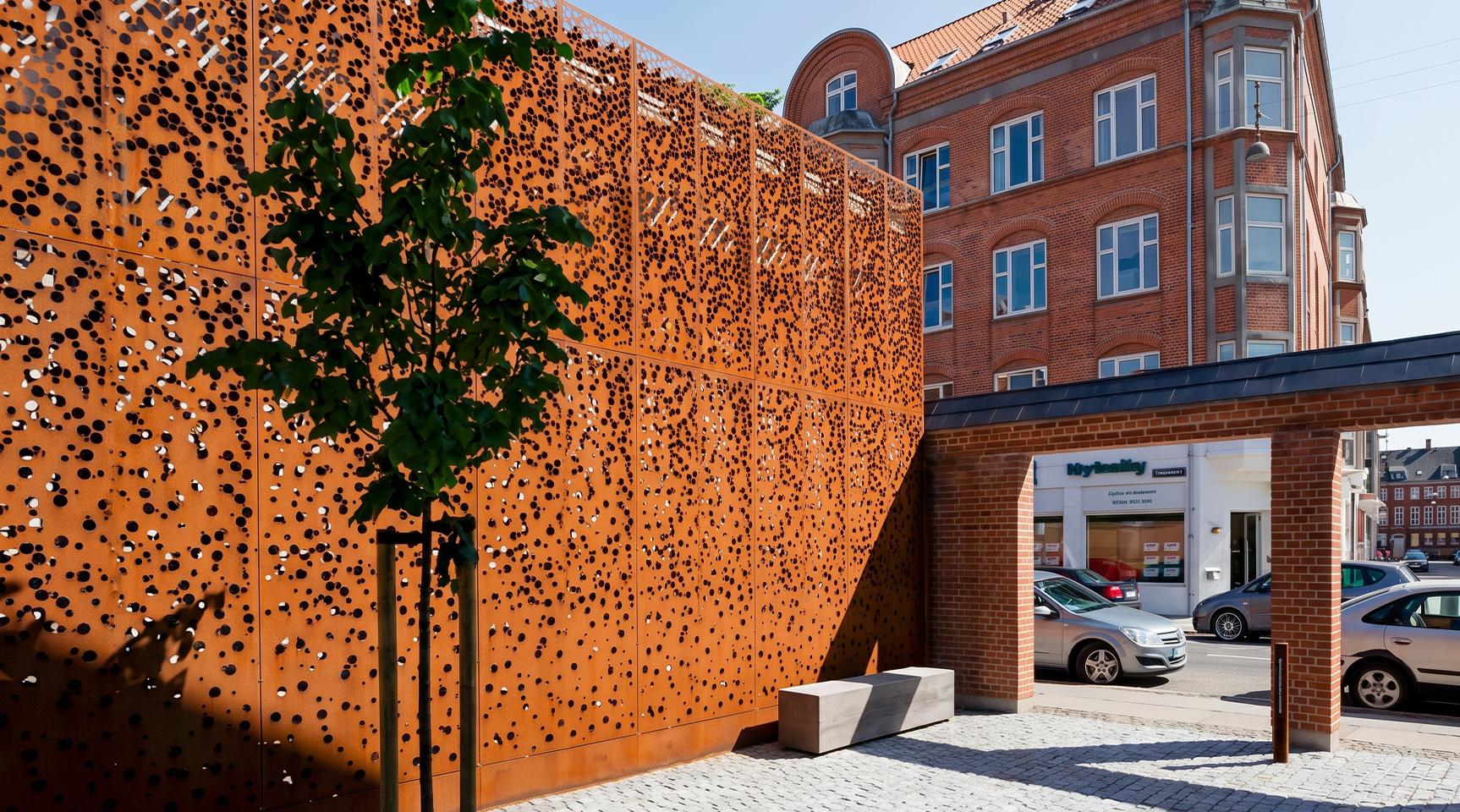 Façade perforée en acier Corten sur un bâtiment hôtelier en milieu urbain