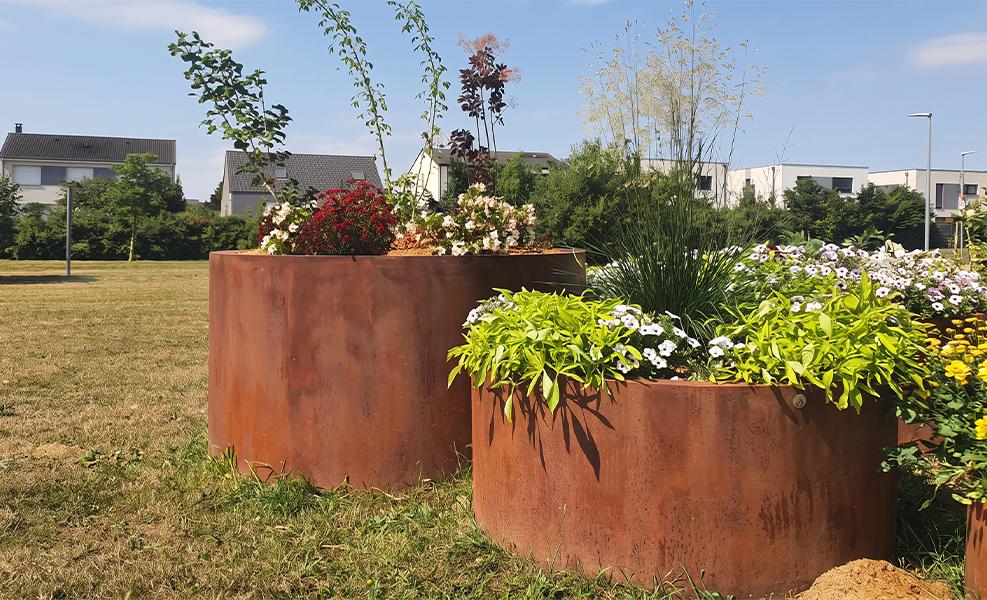 Jardinières rondes en acier Corten dans un aménagement paysager