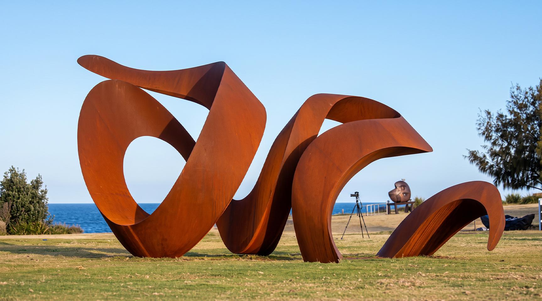 Sculpture monumentale aux formes organiques courbes en acier Corten en extérieur